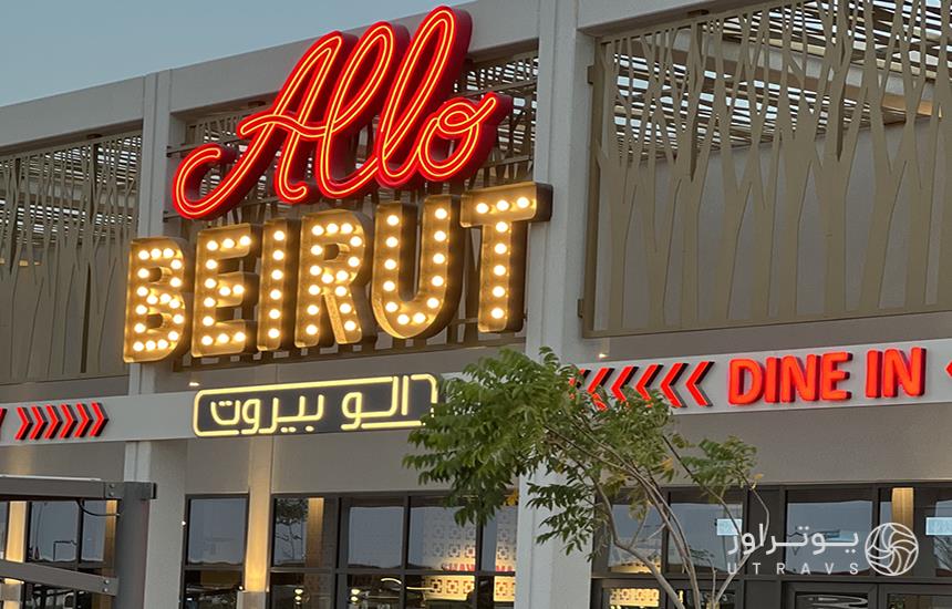 نمای ساختمان «الو بیروت» دبی که تابلوی نئونی رستوران را به دو زبان عربی و فارسی نشان می‌دهد.